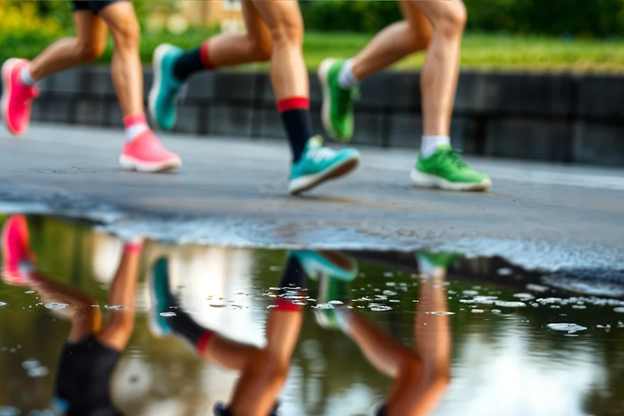 Reflexo de corredores sobre o asfalto molhado